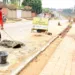 Estudantes caminham por calçada em construção na periferia