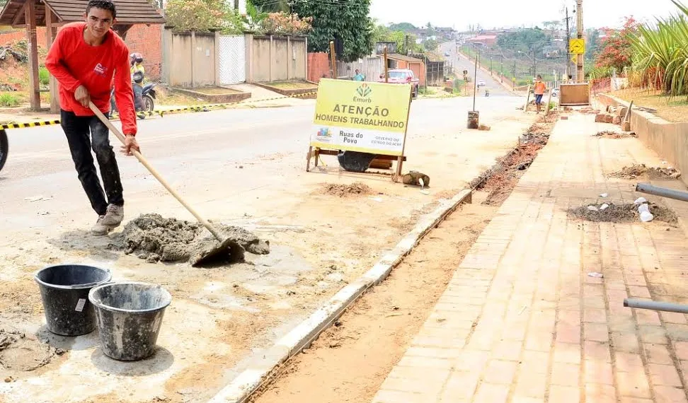 Estudantes caminham por calçada em construção na periferia