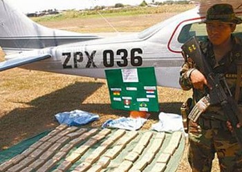 Soldado posa ao lado de aeronave e dos entorpecentes: brasileiro está entre presos