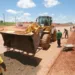 Máquina e operários em obra na periferia de Rio Branco