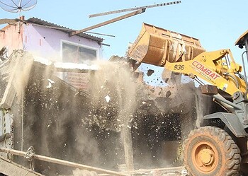 Trator remove escombros após residência ser demolida