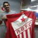 No aeroporto de Rio Branco, o ex-jogador de vôlei Giba tira foto com a bandeira do Rio Branco