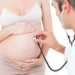 Gynecologist examining a pregnant woman in his surgery