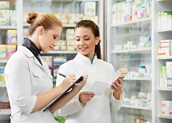 two pharmacist chemist women working in pharmacy drugstore