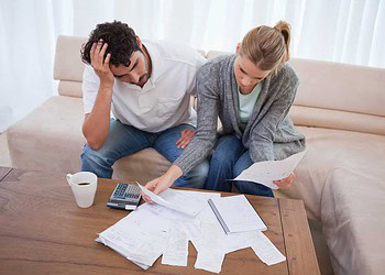 Depressed couple doing their accounting in their living room