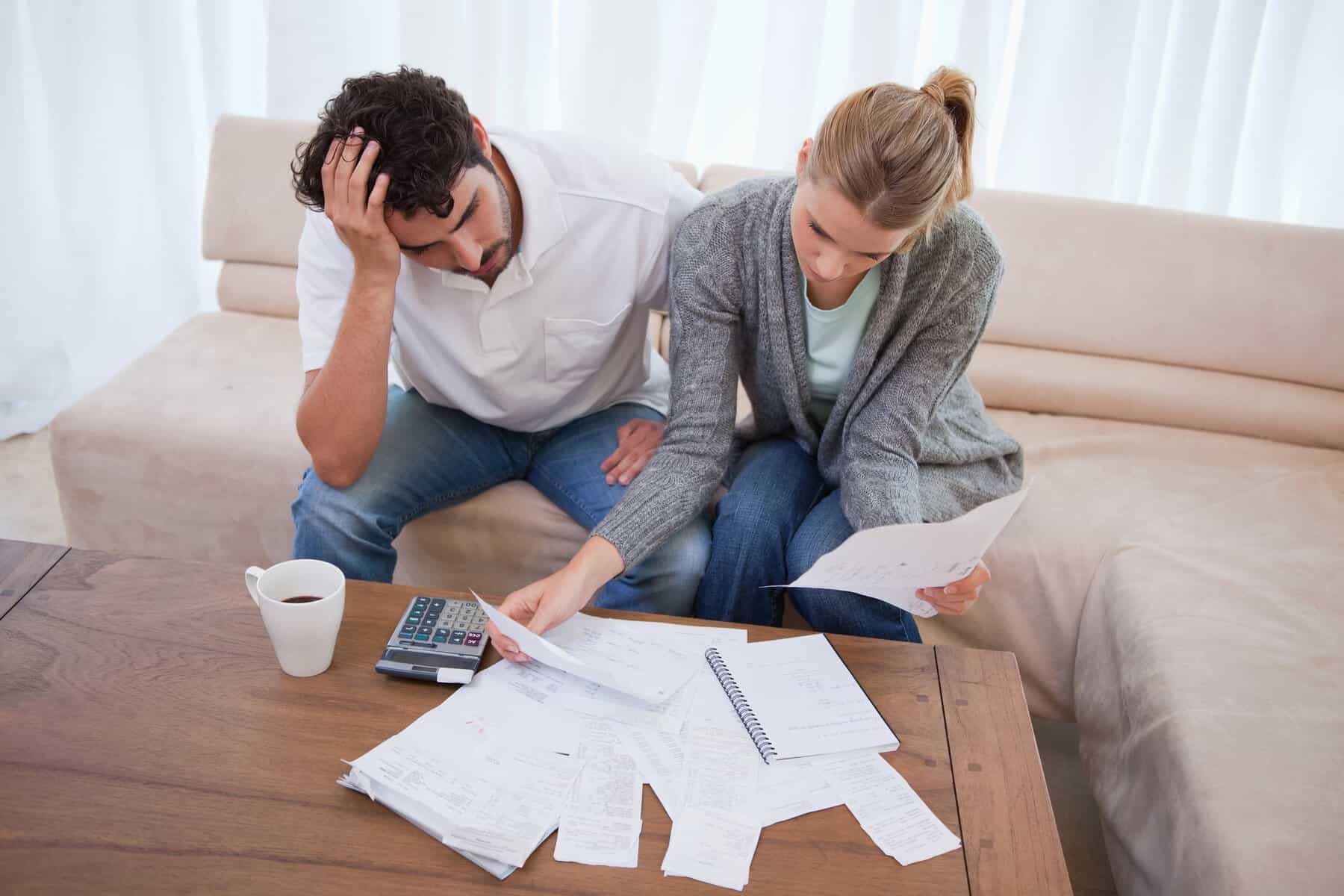 Depressed couple doing their accounting in their living room