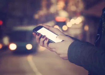 Using cellphone with defocused city - traffic lights.