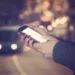Using cellphone with defocused city - traffic lights.