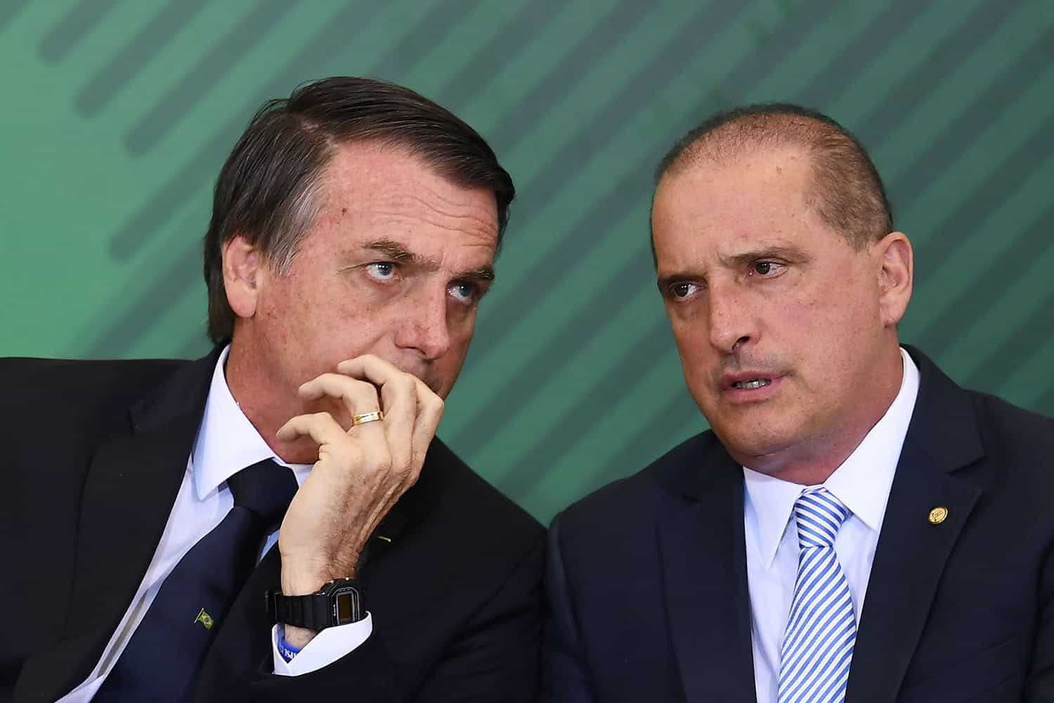 Brazilian President Jair Bolsonaro (L) talks to Chief of Staff Onyx Lorenzoni during the appointment ceremony of the new heads of public banks, at Planalto Palace in Brasilia on January 7, 2019. - Brazil's Finance Minister Paulo Guedes appointed the new presidents of the country's public banks. (Photo by EVARISTO SA / AFP)