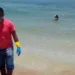 O voluntário Robério Nunes ajuda no trabalho de retirada de óleo de praia em Morro de São Paulo, na Bahia