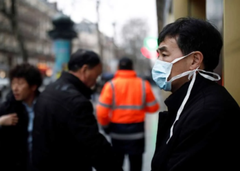 Um turista usa uma máscara protetora em frente à loja de departamentos Galeries Lafayette, em Paris, quando o país é atingido pelo novo coronavírus, na França, em 30 de janeiro de 2020.