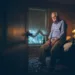 Depressed senior man alone sitting on bed edge with dozens of pill container at his feet