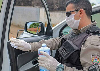 Policiais passam álcool em gel para higienizar viaturas, durante o serviço (FOTO: Jean Messias)