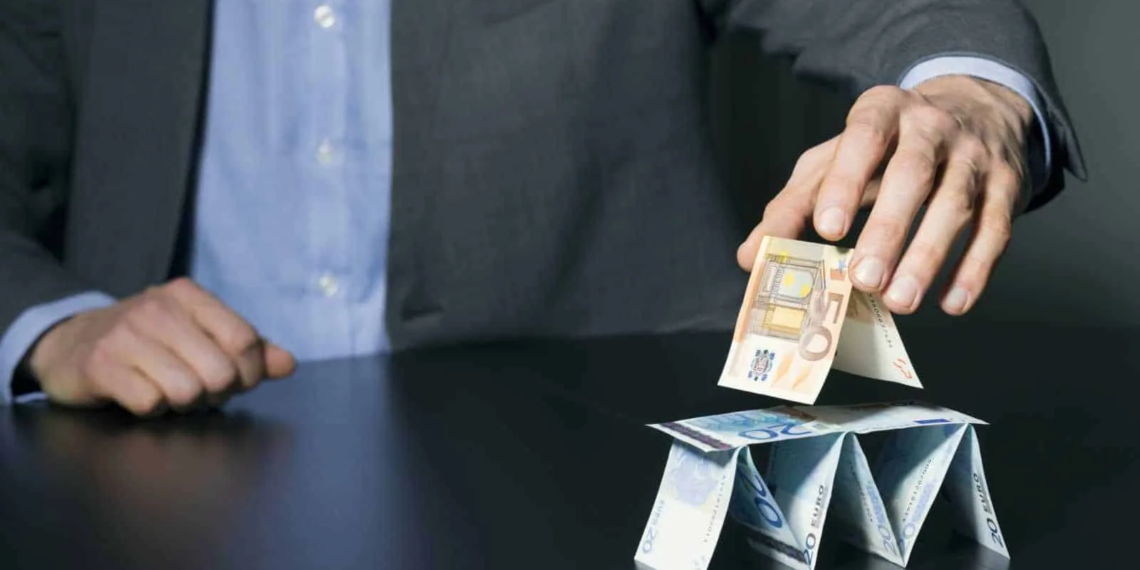 businessman building financial pyramid from euro paper money