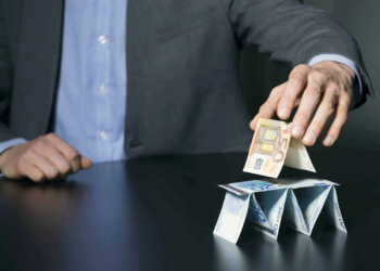 businessman building financial pyramid from euro paper money