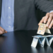 businessman building financial pyramid from euro paper money