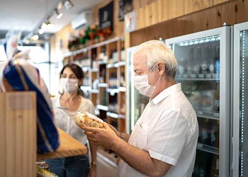 Senior couple buying with face mask at store