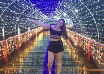 A acadêmica de arquitetura Luciene Garcia recebendo 2022 na praia de São Sebastião em São Paulo