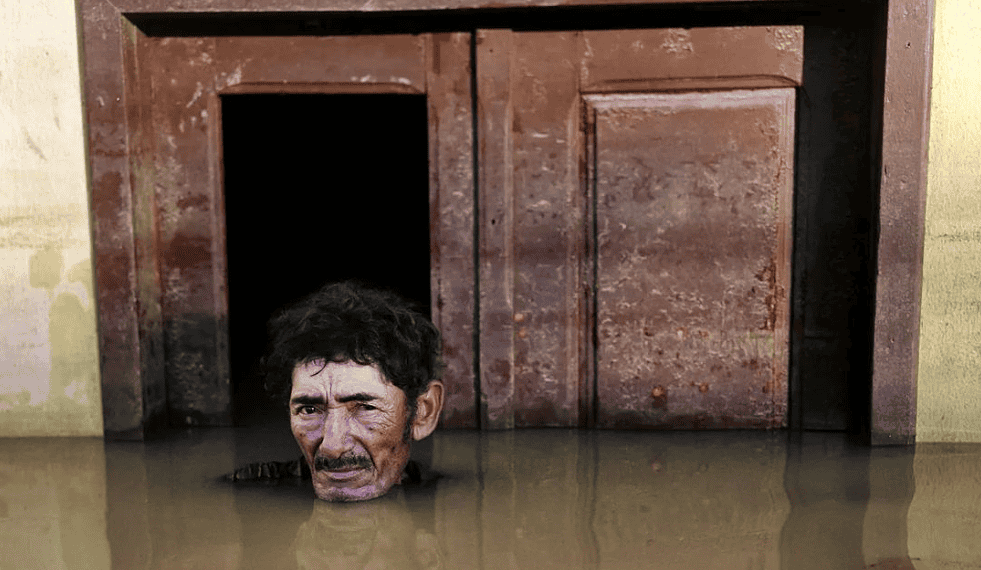 Fotografia que compõe o livro: João Pereira de Araújo, morador do Taquari, durante cheia do Rio Acre em março de 2015. (Foto: Gideon Mendel).