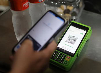 Pessoa faz pagamento por PIX com celular em loja do Rio de Janeiro • 01/04/2024. REUTERS/Pilar Olivares