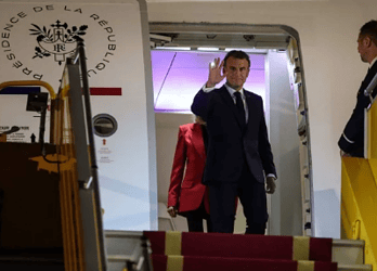 Visivelmente surpreso, o presidente rapidamente se volta para a imprensa e acena, tentando retomar a compostura - (crédito: Ludovic MARIN / AFP)