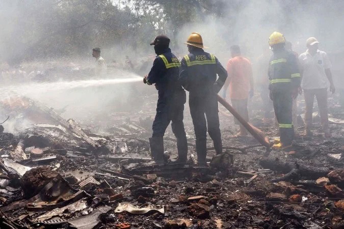 Equipes de resgate trabalham no local onde o avião caiu na Índia - (crédito: Sam PANTHAKY/AFP)