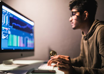 Indian trader checking stock trading data analysis concept working in office with financial graph on computer monitors