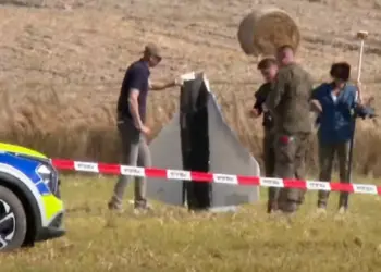 Policiais e militares poloneses inspecinam destroços de drone, abatido por caças, em Wohyń, na Polônia, em 10 de setembro de 2025. — Foto: Rafal Niedzielski/AP