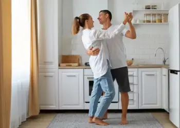 Quer durar no amor? Psicólogo revela 5 segredos que mantêm casais felizes por décadas 2 Casal dança feliz na cozinha — Foto: Freepik