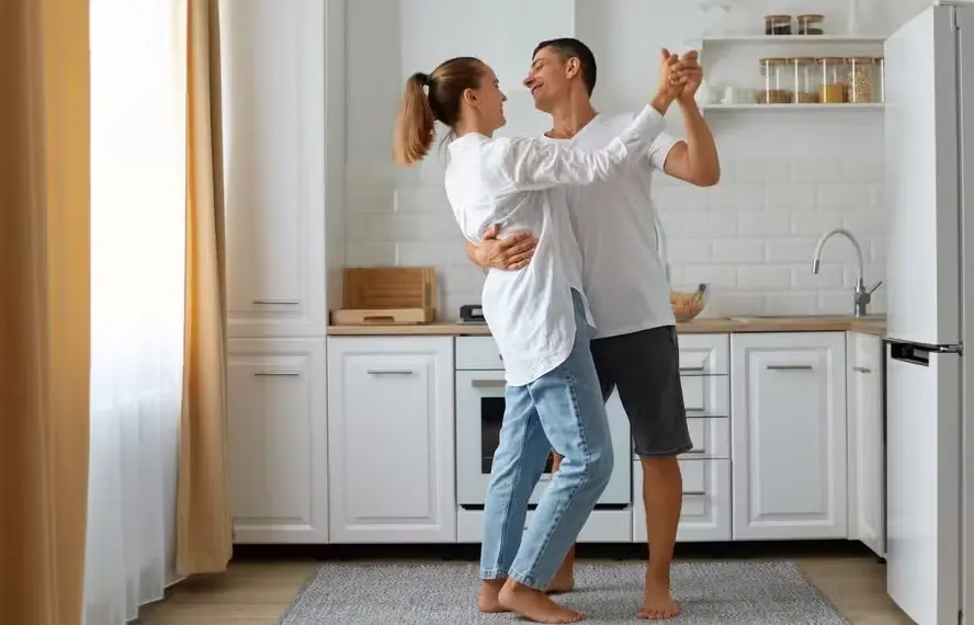 Casal dança feliz na cozinha — Foto: Freepik
