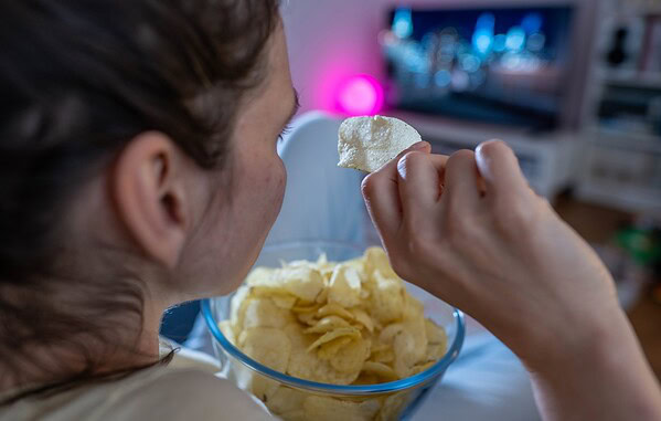 Por que comer em frente à TV confunde o cérebro e favorece exageros