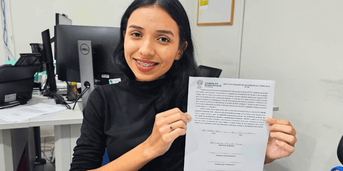 Hillary apresenta o termo de compromisso assinado, documento que a legitima como bolsista não docente do Ieptec. Foto: Ascom/Ieptec.
